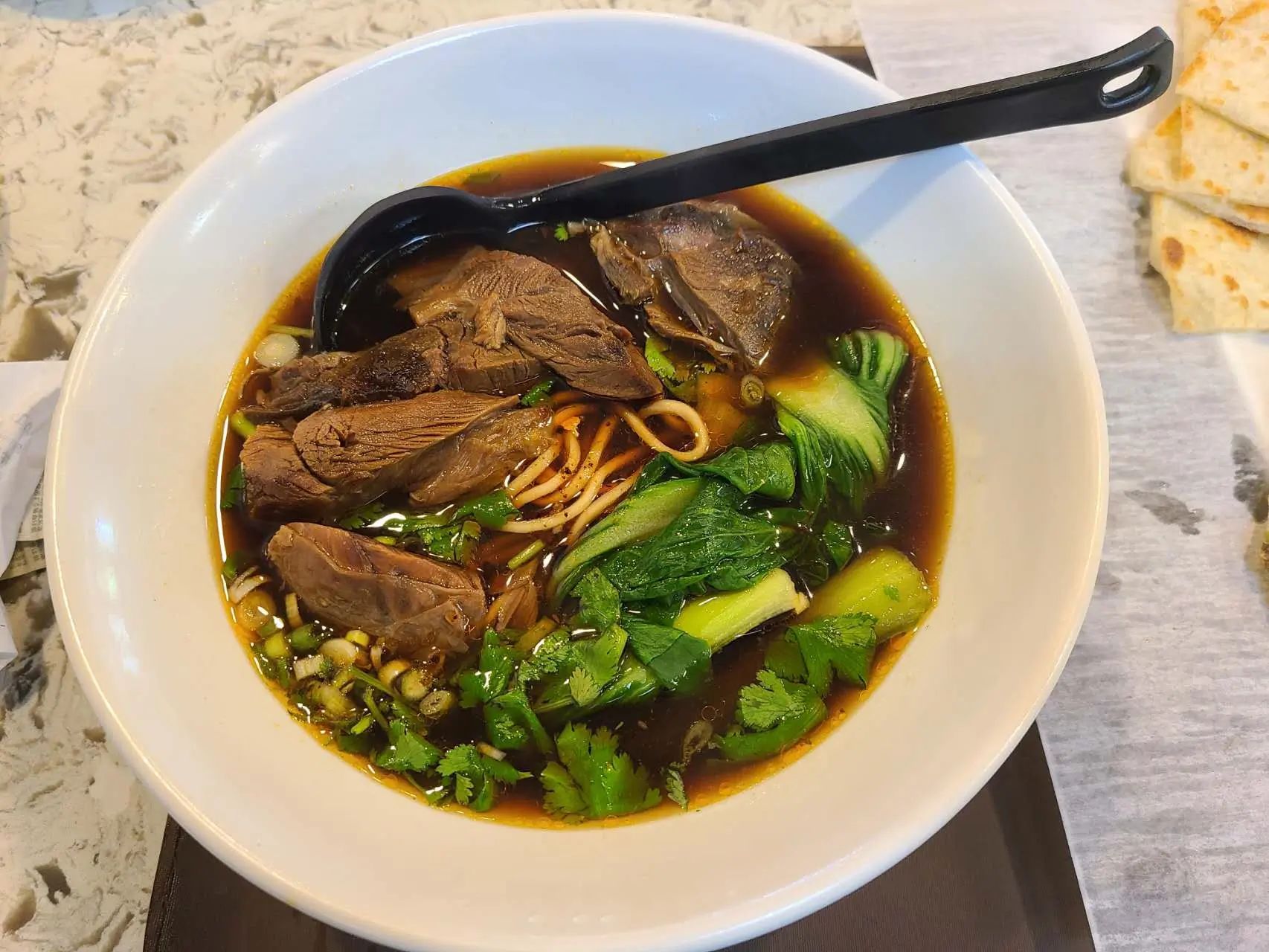 Beef noodle soup with greens and cilantro at 1st Dumpling N Noodle, a Chinese Restaurant in CA