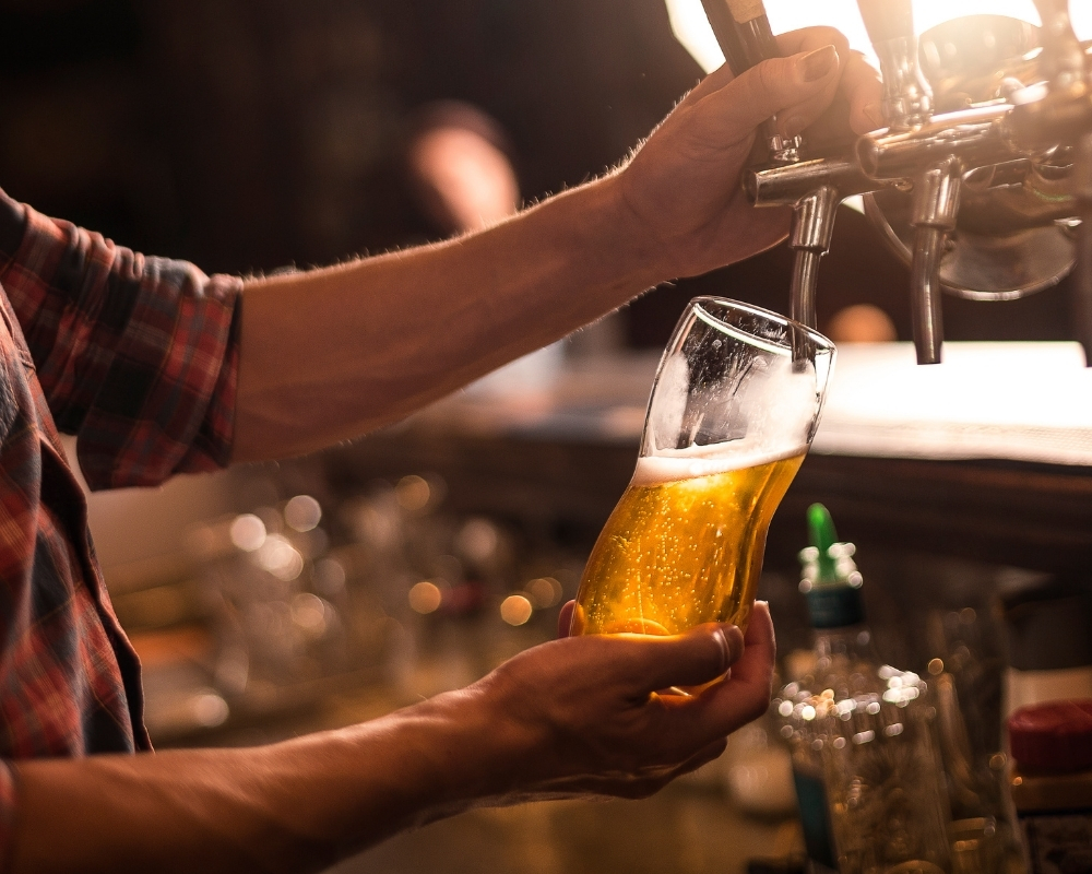 Staff pouring draft beer into a glass at 21 Raw Bar Taphouse & Grill，a Seafood Restaurant in Greenville