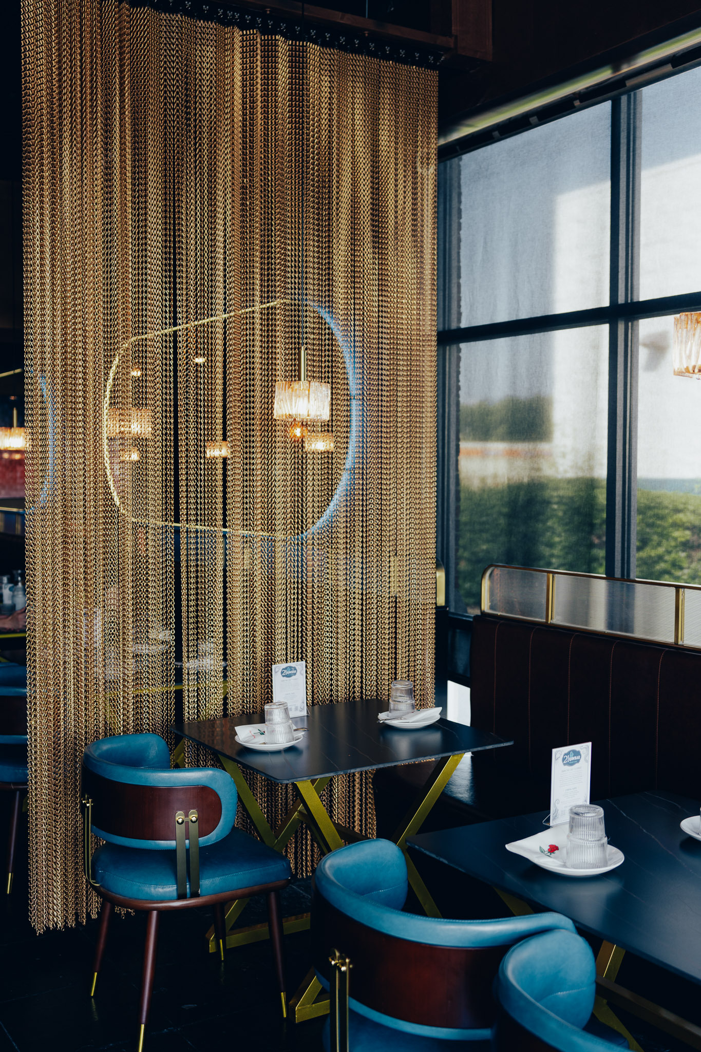 Dining area with golden chain curtain and large window