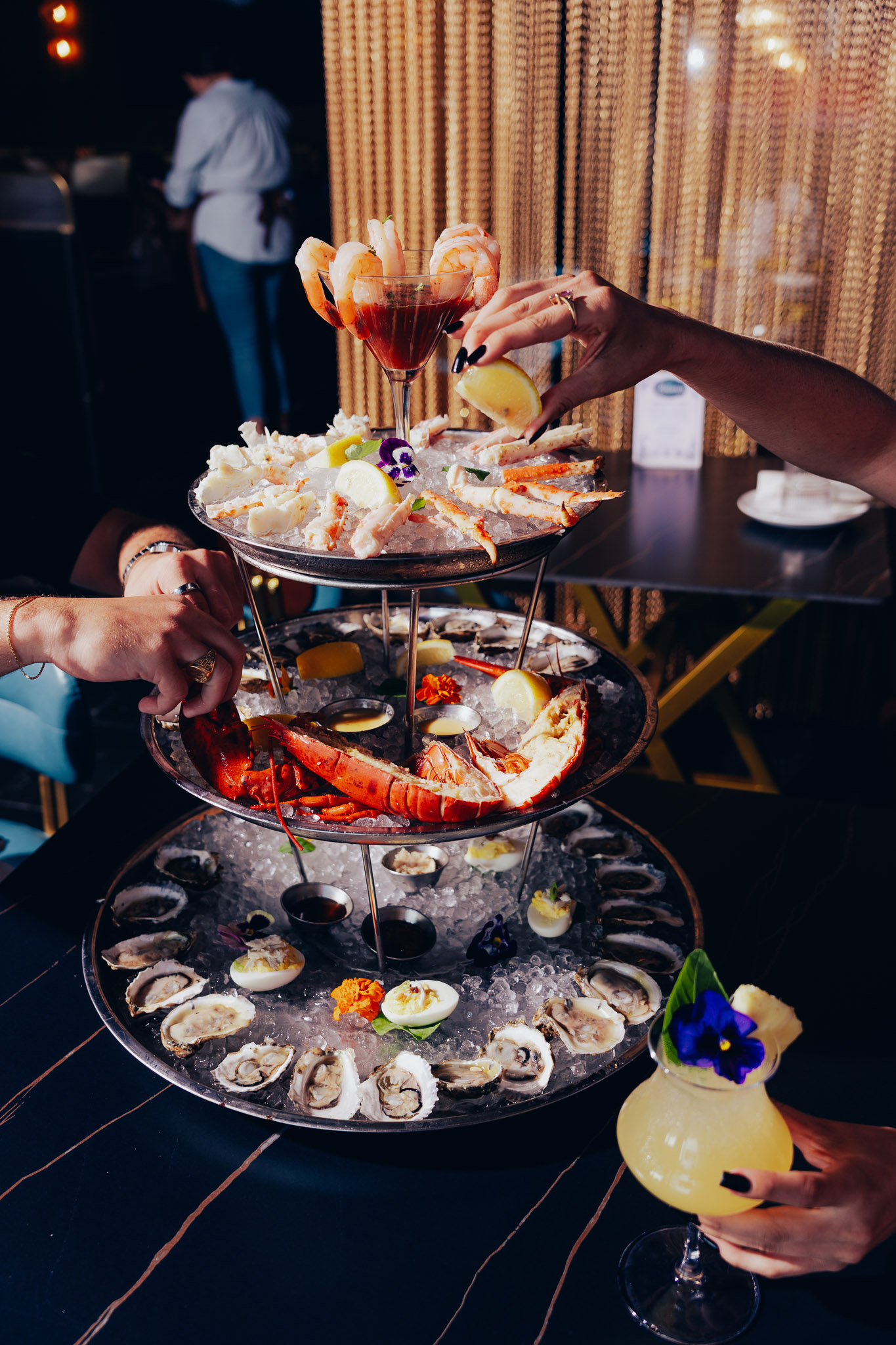 People sharing the multi-level seafood ice tower