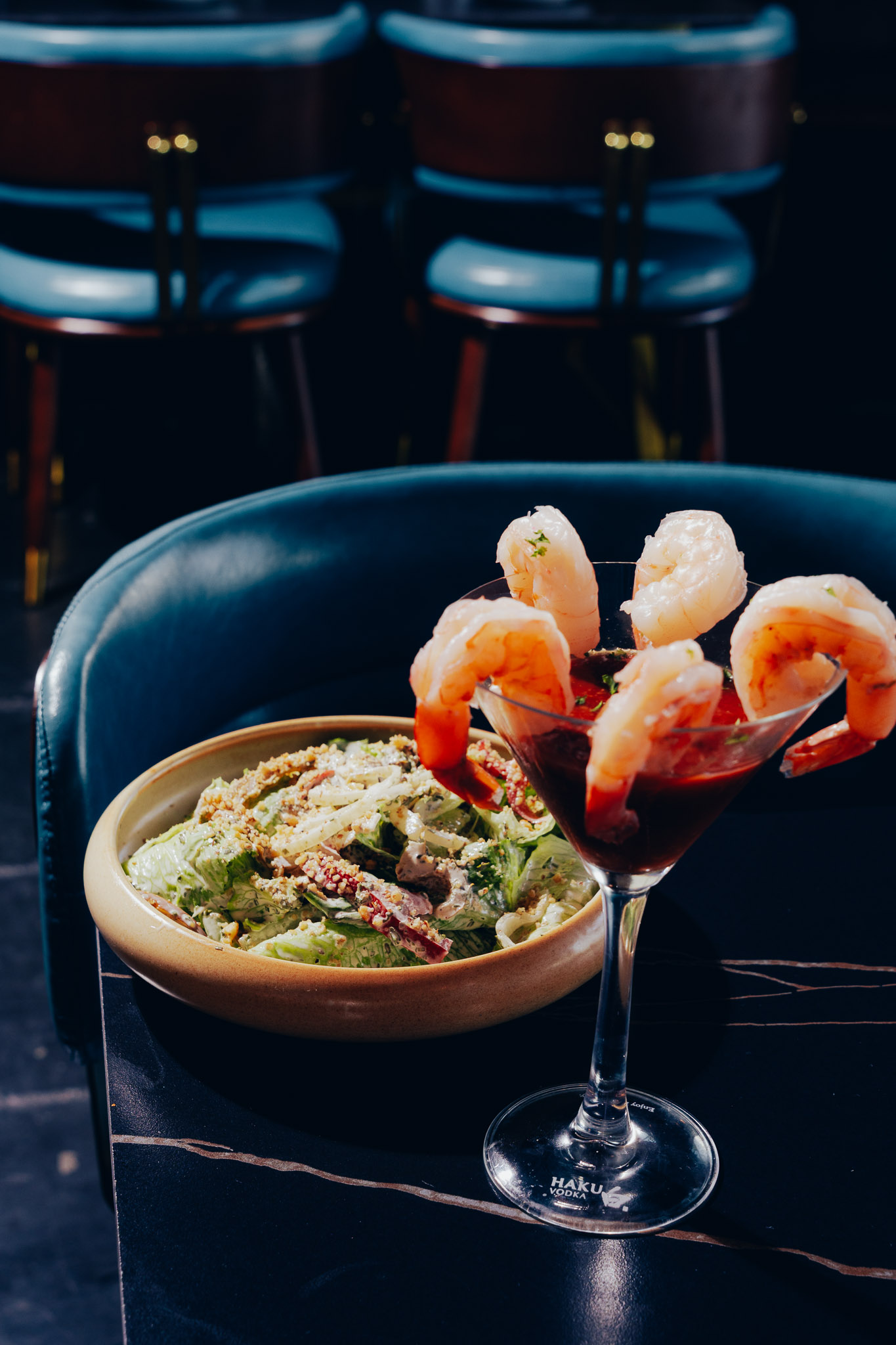 Shrimp cocktail beside fresh caesar salad