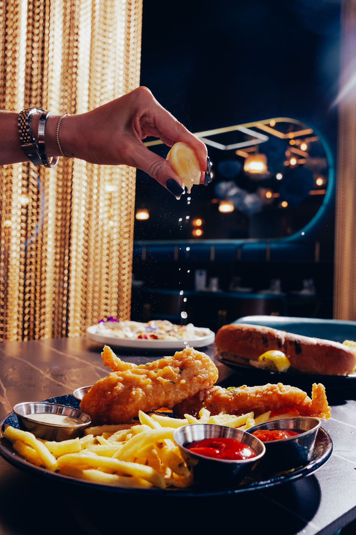 Squeezing lemon juice over crispy fish and chips