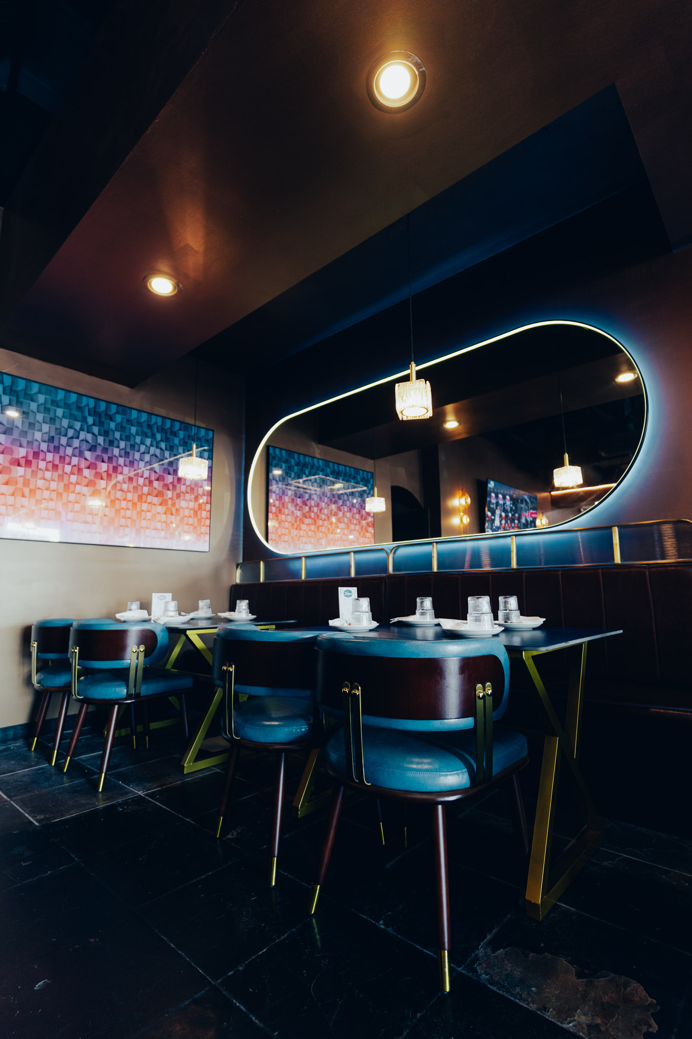 Stylish restaurant booth with neon mirror and gradient wall art