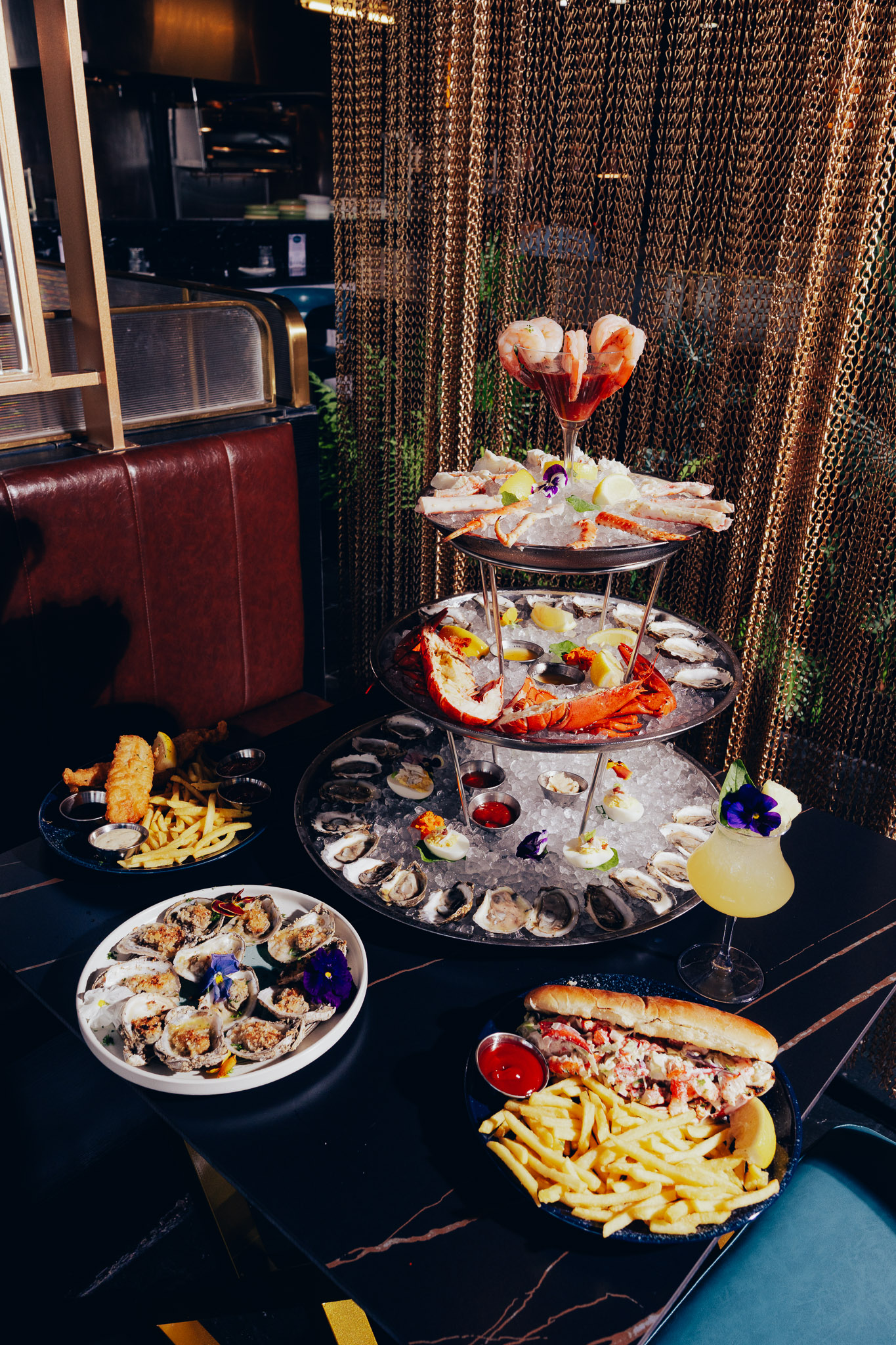 Three-tiered chilled seafood tower with sides and cocktails