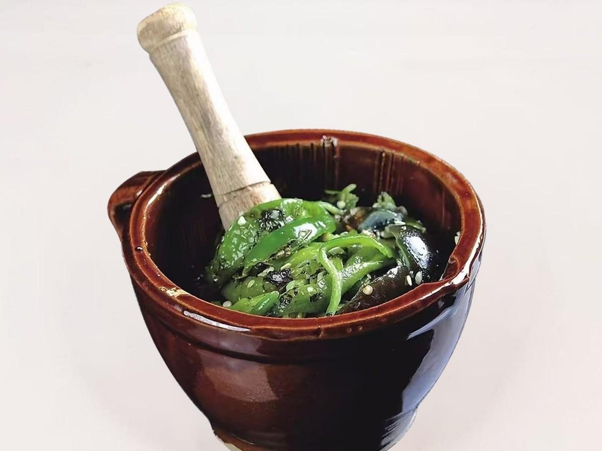 Smashed eggplant mixed with green pepper in a mortar at 28° North Old Changsha, a Chinese Restaurant in Rowland Heights.