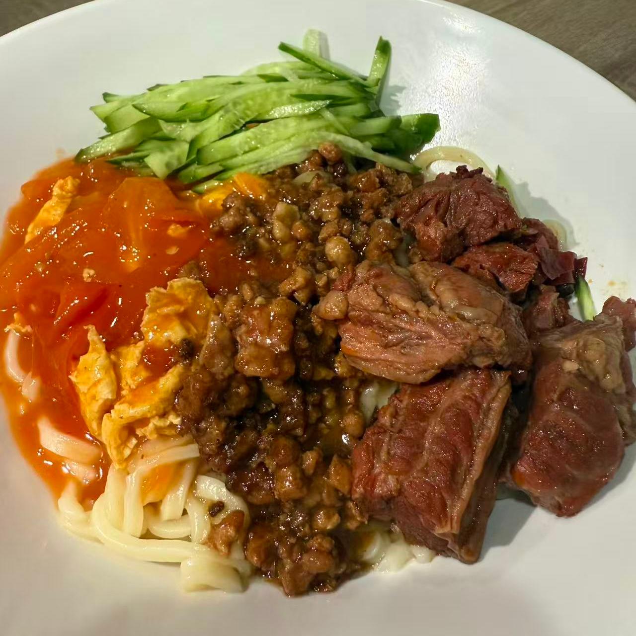 Noodles mixed with tomato - egg sauce, minced meat, and beef chunks, plus cucumber shreds at 3 He Noodles, a Chinese Restaurant in Temple City