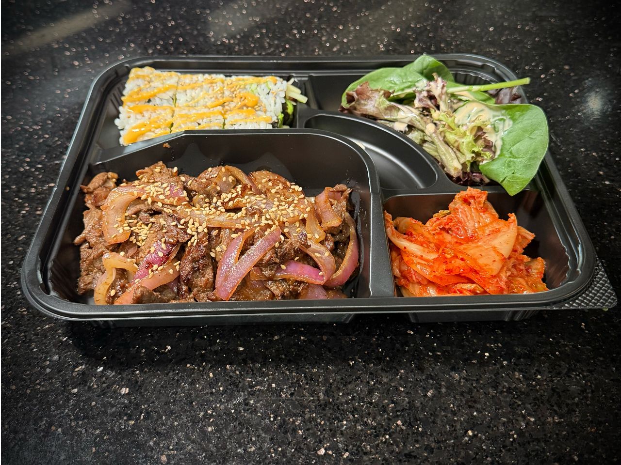 Beef bulgogi bento box with rice and fresh side vegetables at 592 Korean BBQ, an Asian Fusion Restaurant in Appleton