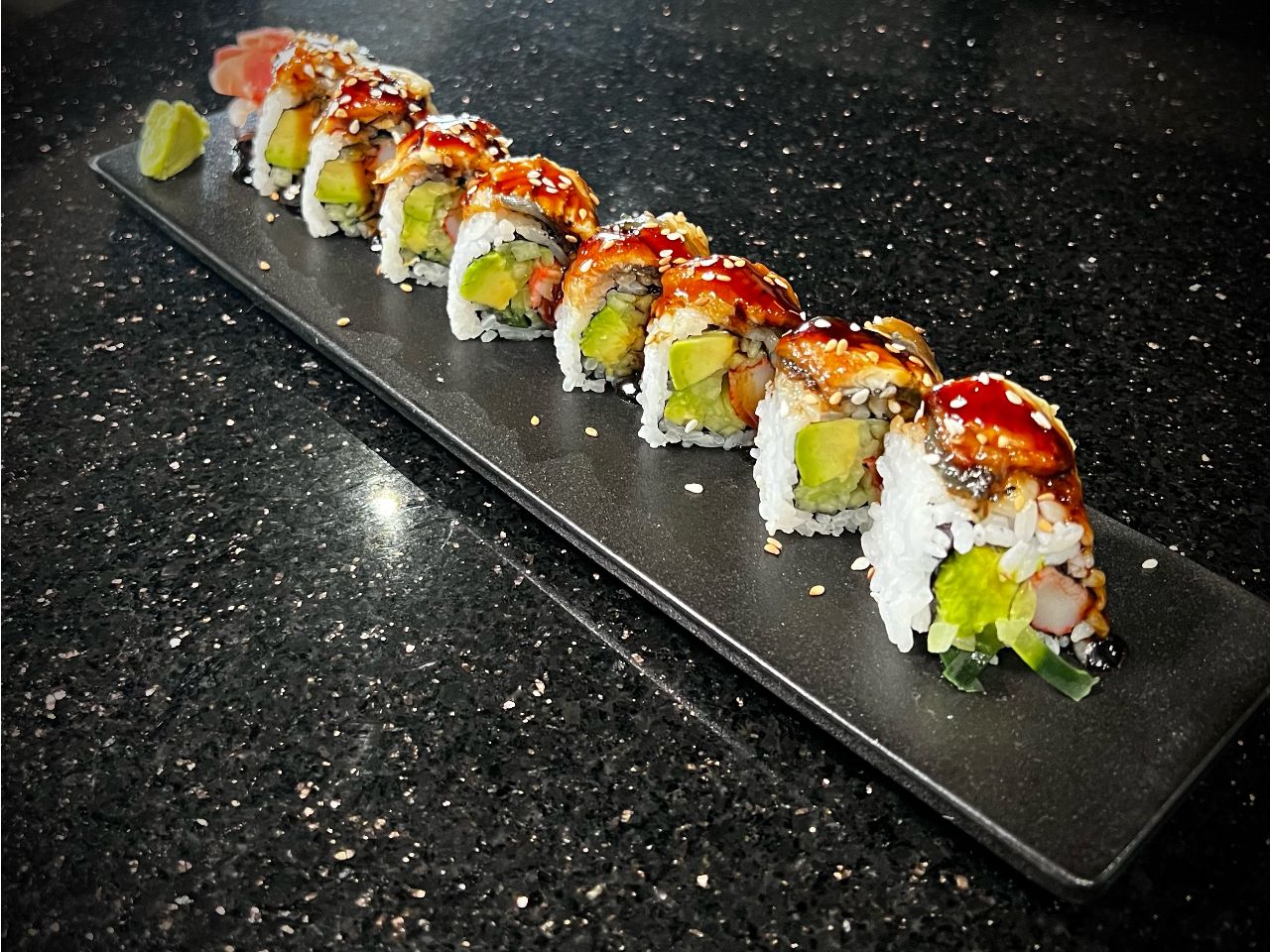 Dragon sushi roll layered with avocado and savory drizzled sauce at 592 Korean BBQ, an Asian Fusion Restaurant in Appleton