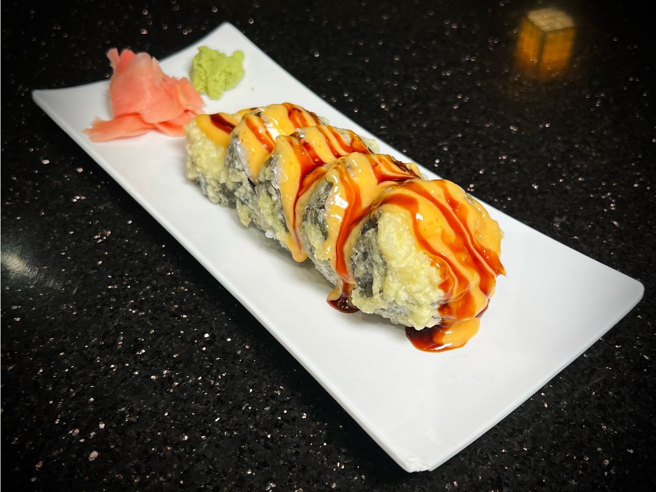 Fried crab cream cheese sushi roll with rich savory drizzled sauce at 592 Korean BBQ, an Asian Fusion Restaurant in Appleton