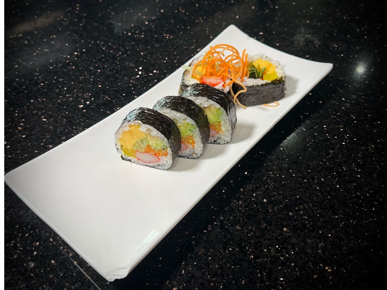 Classic futomaki sushi roll packed with mixed vegetable fillings on white plate at 592 Korean BBQ, an Asian Fusion Restaurant in Appleton