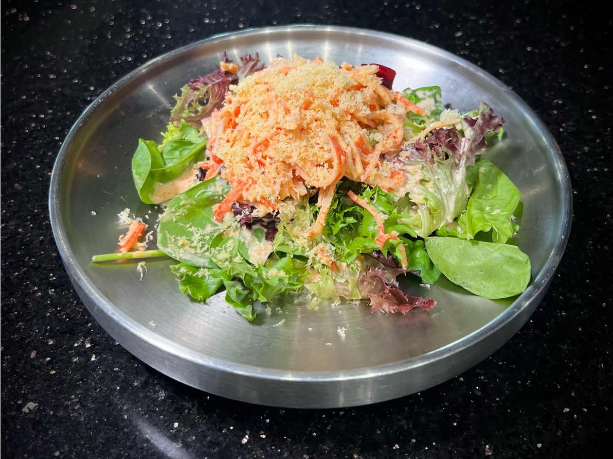 Spicy crab salad tossed with fresh greens served on round metal plate at 592 Korean BBQ, an Asian Fusion Restaurant in Appleton