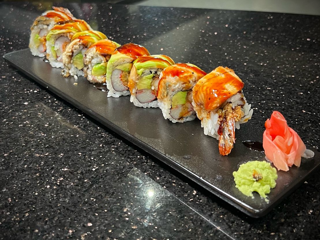 Tokyo sushi roll with mixed seafood and vibrant garnish on dark plate at 592 Korean BBQ, an Asian Fusion Restaurant in Appleton