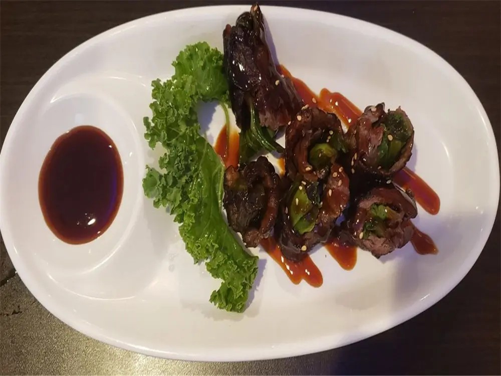 Beef-wrapped appetizers with sauce at E Sushi & Grill, a Japanese Restaurant in Apollo Beach