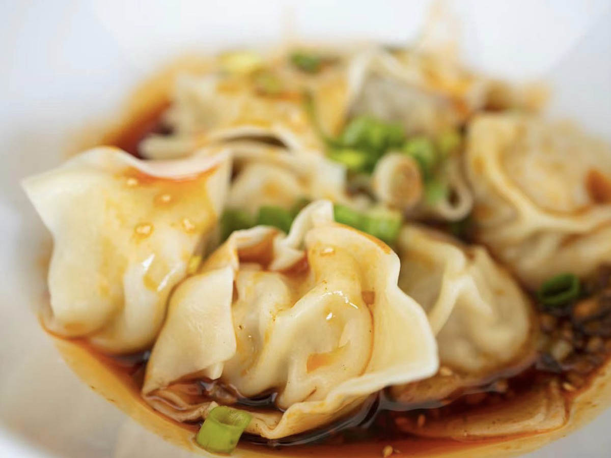 Spicy Chicken Wonton in a bowl, with wontons swimming in a spicy sauce at Seven Folding Dumpling House，a Chinese Restaurant in Mission Viejo