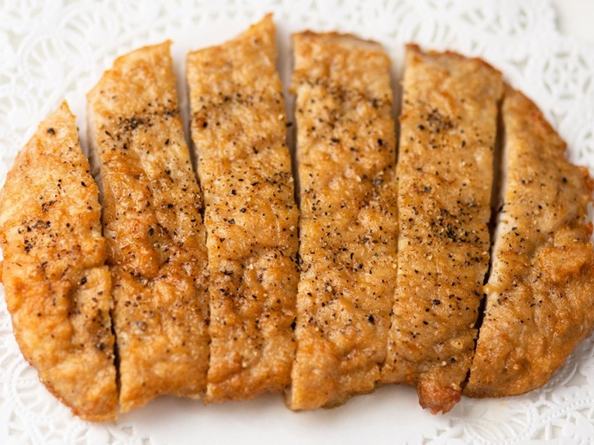 Deep - fried Pork Chop, sliced and served on a plate, crispy on the outside at Seven Folding Dumpling House，a Chinese Restaurant in Mission Viejo