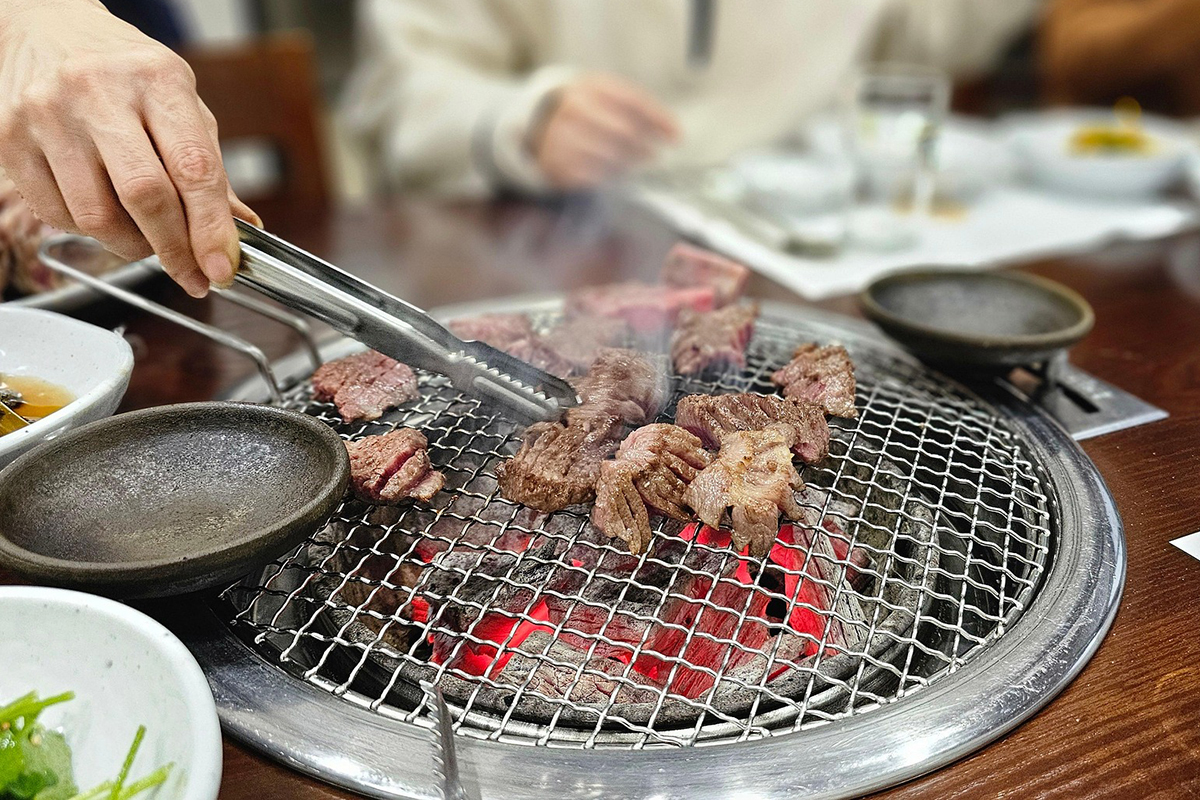 88-Korean-BBQ-and-Hot-Pot-Asian-Fusion-Restaurant-Charcoal-Grilled-Meat-Frisco pieces of meat being grilled over a charcoal fire at 88 Korean BBQ and Hot Pot,a Asian Fusion Restaurant in Frisco