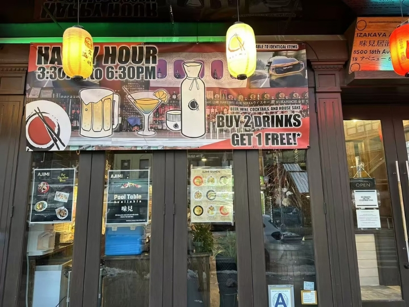 Exterior with happy hour sign at Ajimi, a Ramen Restaurant in Brooklyn