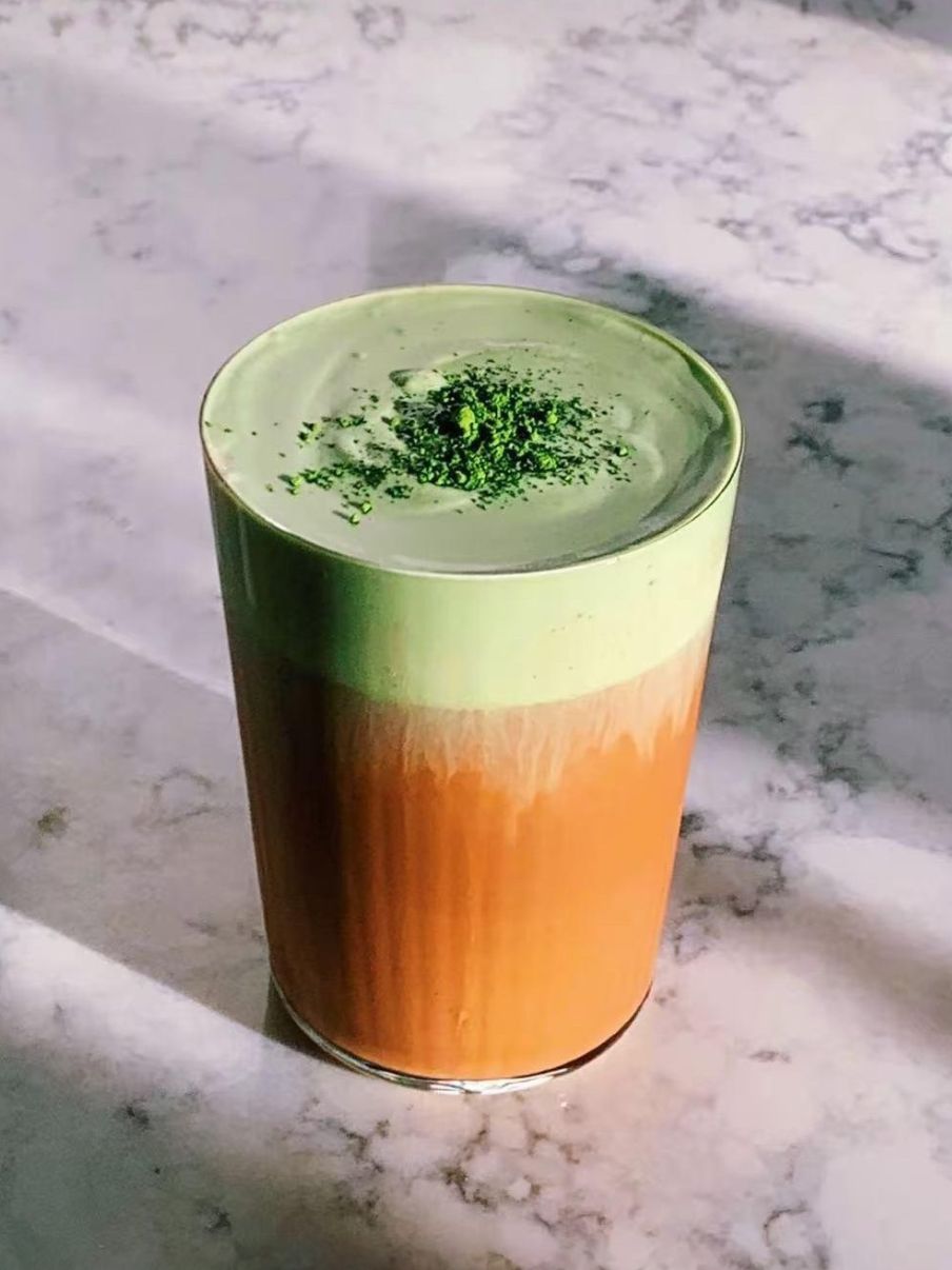 Layered milk tea with matcha foam and green tea powder topping at Akagi, a Japanese restaurant in Rockville