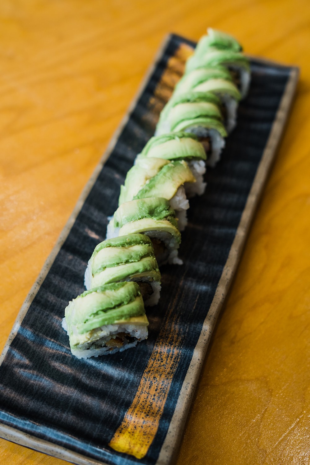 Dragon roll topped with thin slices of fresh avocado