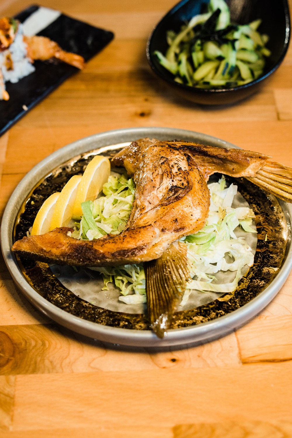 Grilled fish collar served with cabbage and lemon wedges