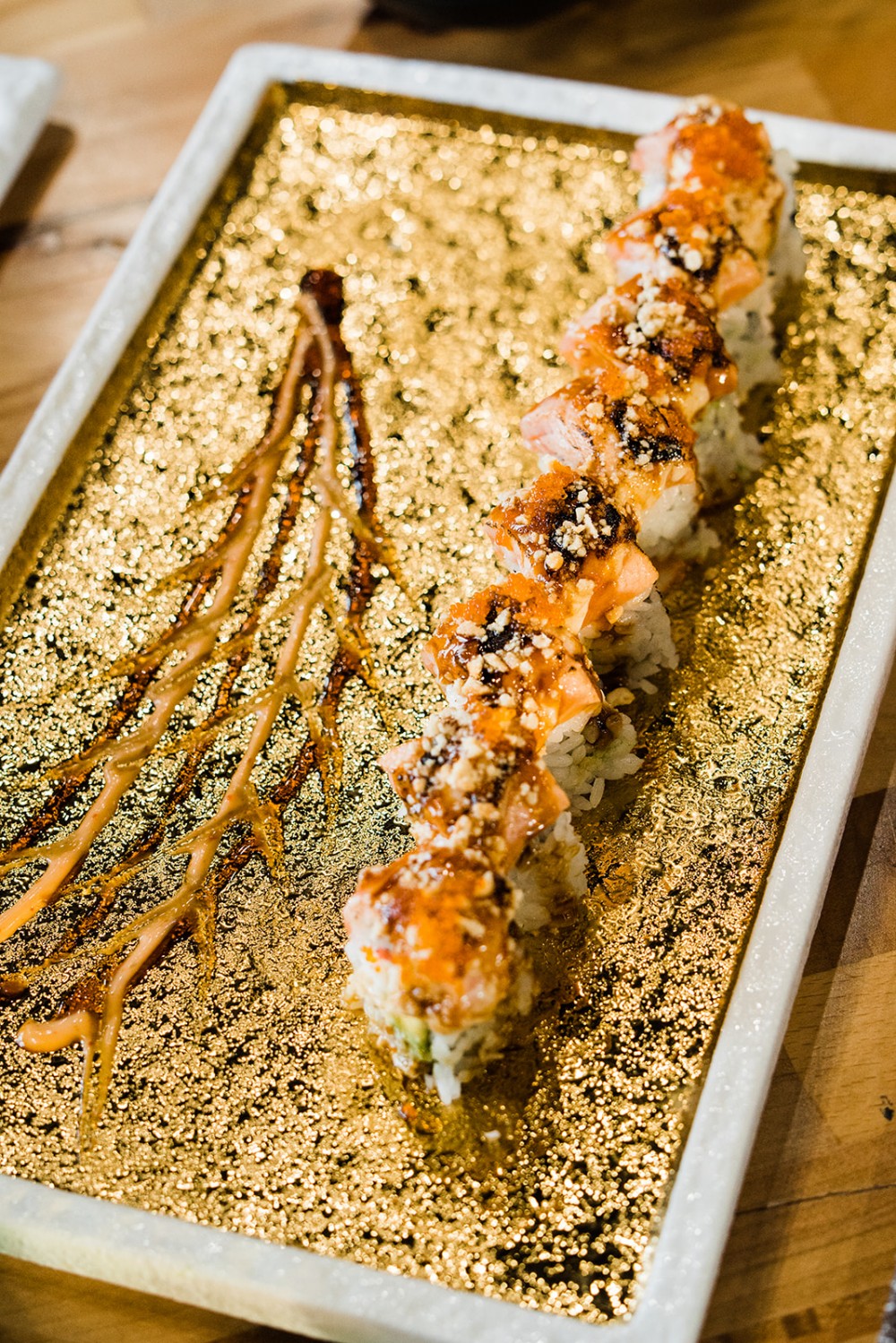 Salmon sushi roll with spicy sauce and crunchy toppings