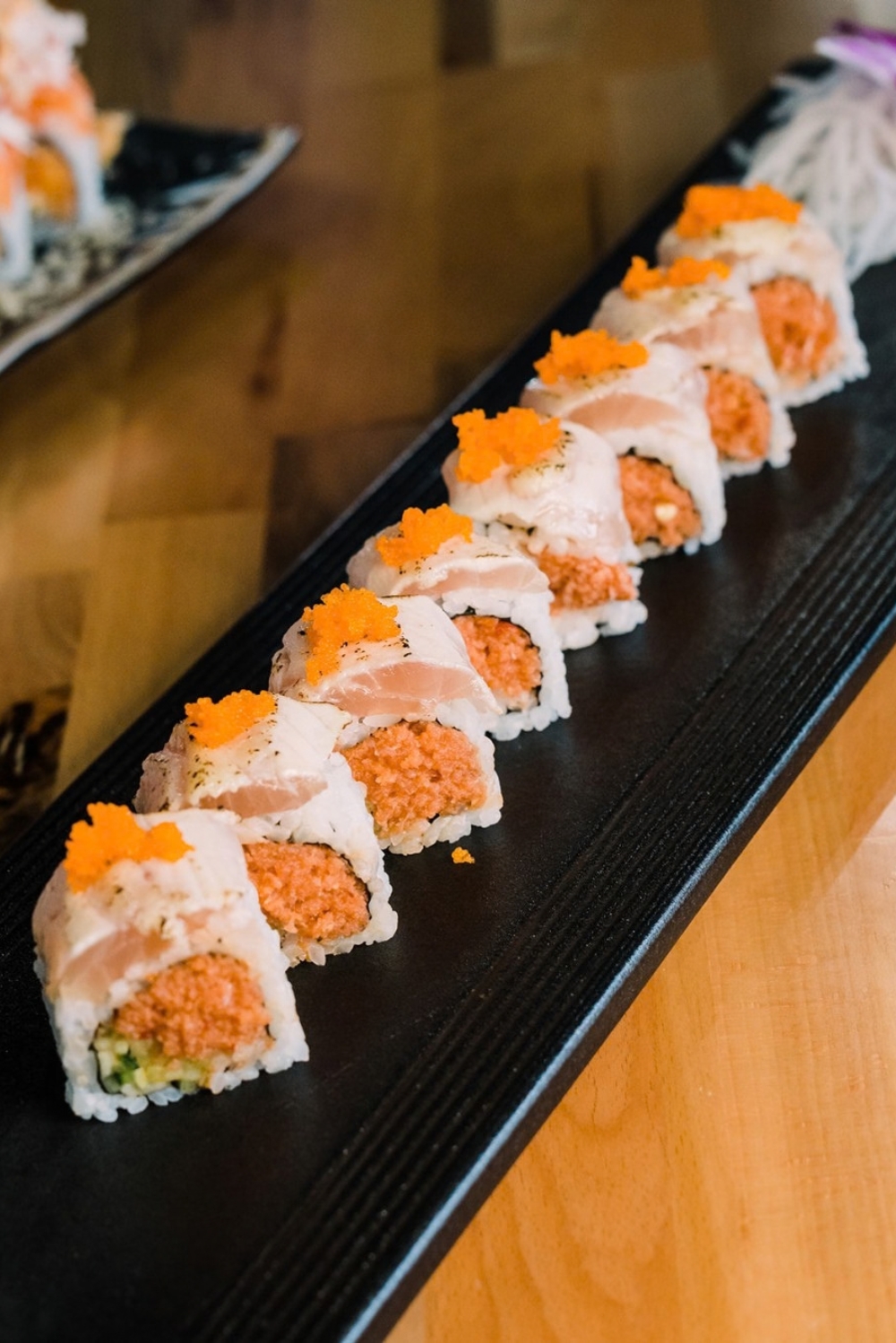 Spicy tuna sushi roll topped with fish roe and white fish