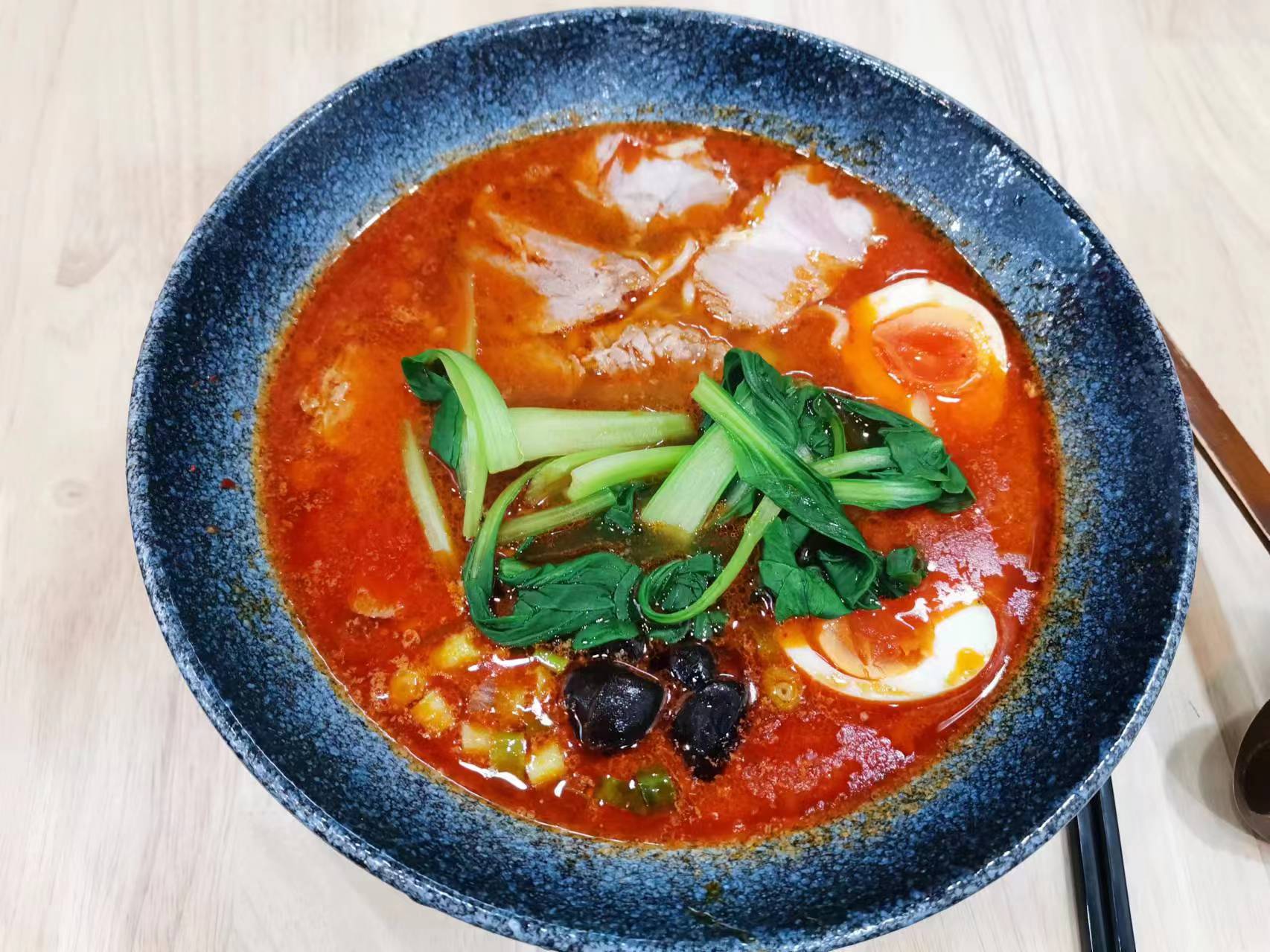 Spicy red ramen with chashu pork, soft-boiled egg, and bok choy at Akiyo, a Japanese Restaurant in Johnson City