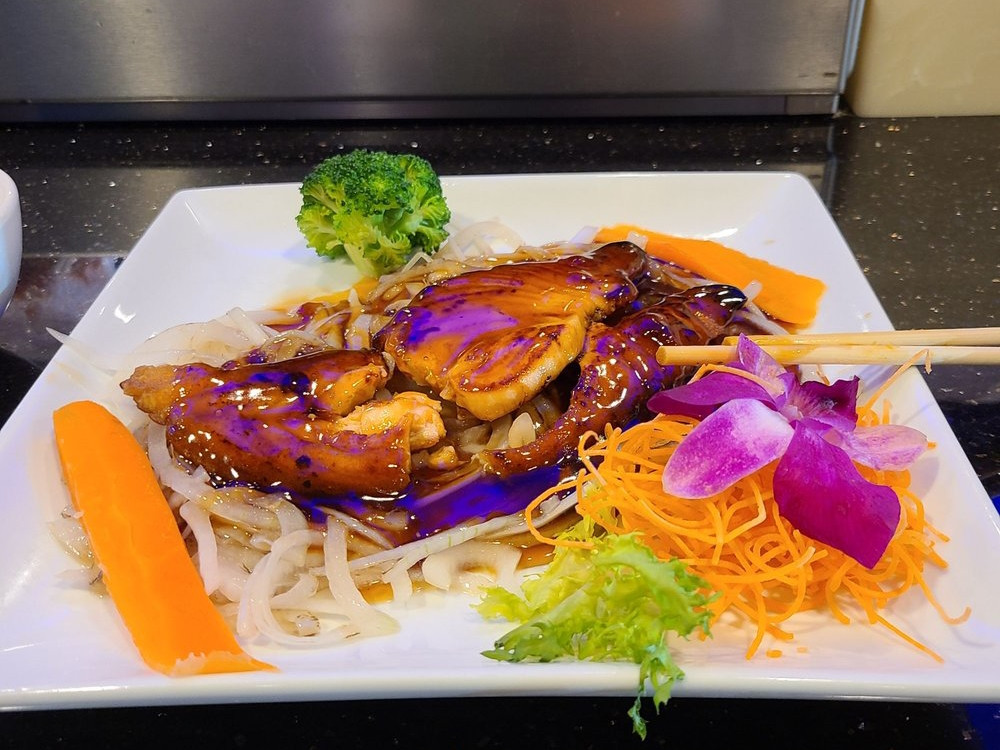 Udon noodles with glazed eel, veggies and orchid garnish at Ako Sushi & Seafood, a Japanese Restaurant in Titusville