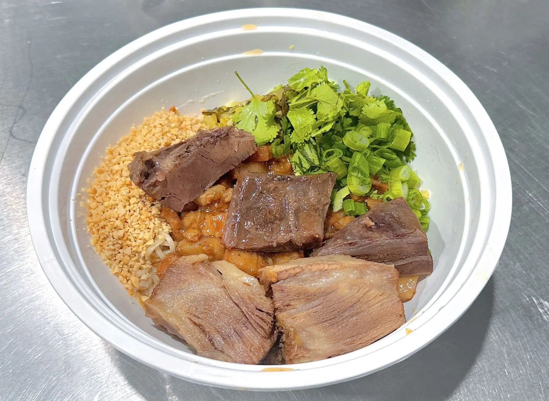 Beef noodle bowl with cilantro and nuts at All In 牡丹，a Chinese Taiwanese Restaurant in Rowland Heights