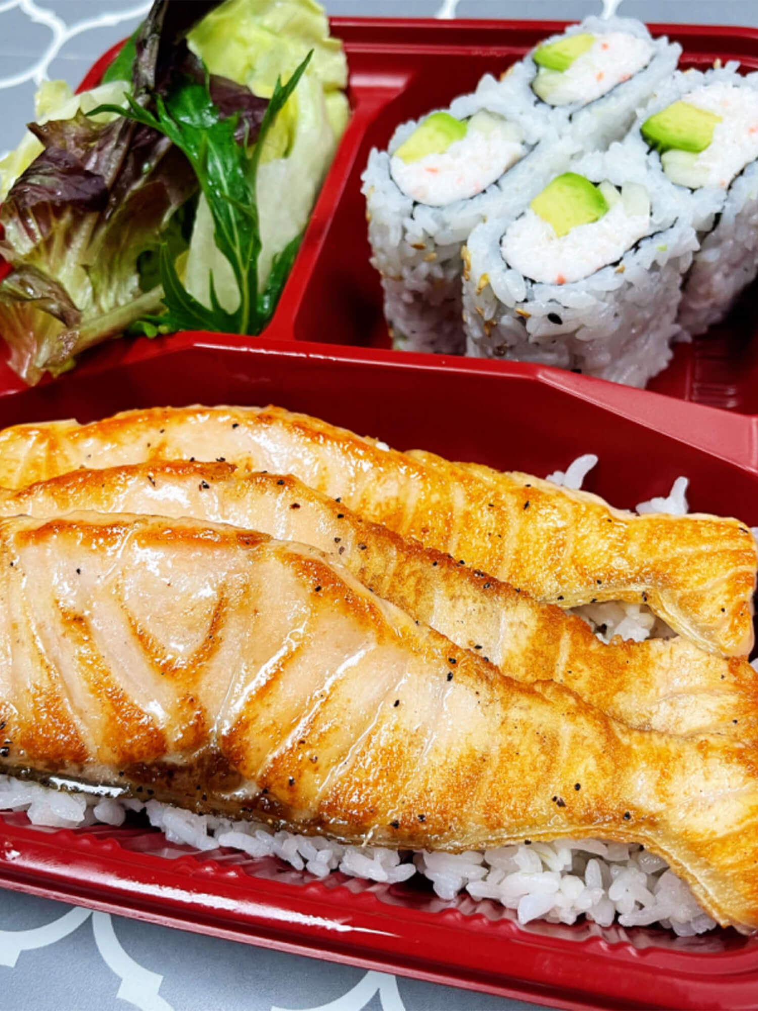 Grilled salmon served with sushi rolls and a side of salad Sushi burrito with chicken, avocado, and vegetables at Aloha Hawaiian BBQ & Sushi, a Asian Fusion restaurant in Baldwin Park