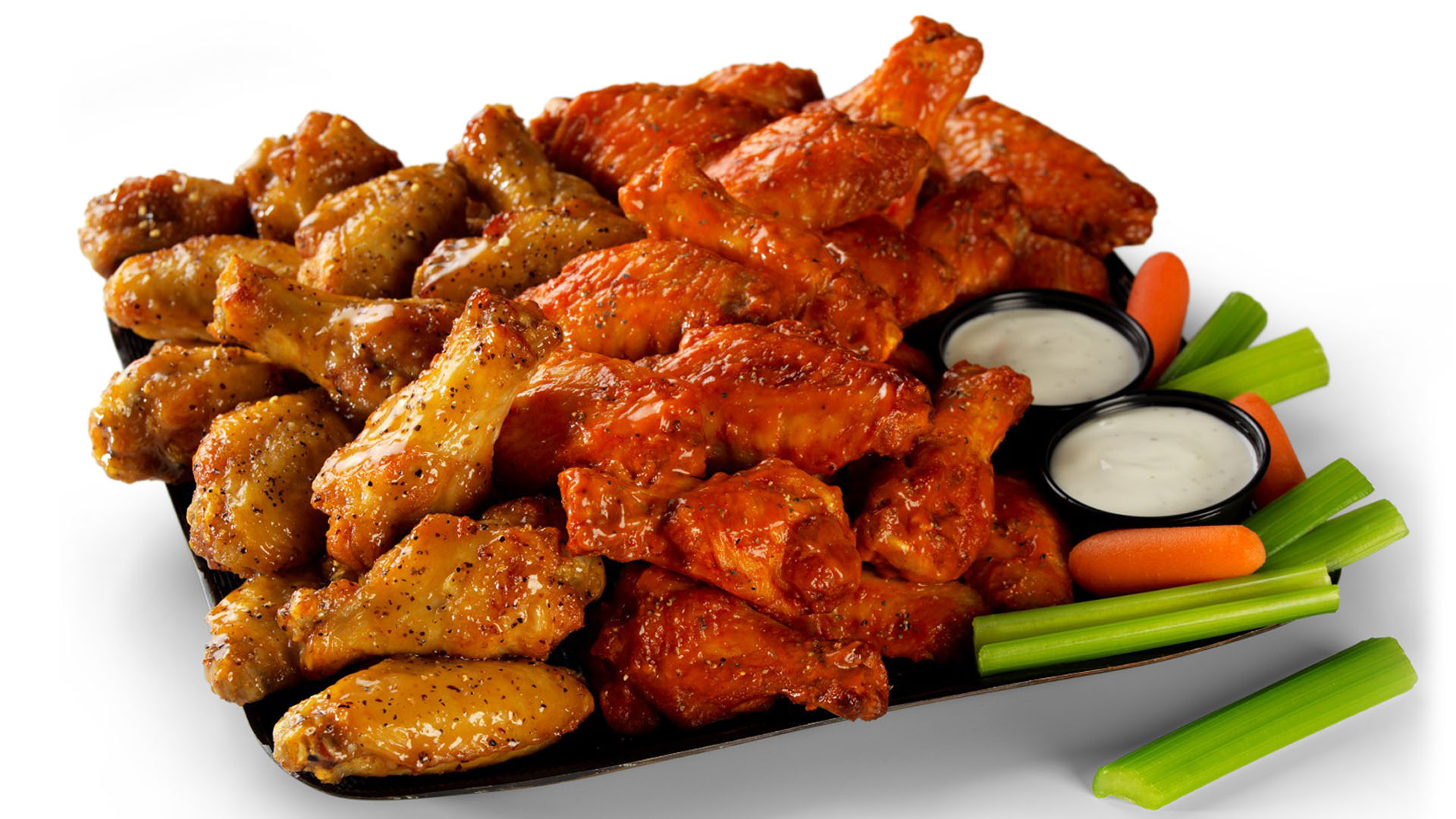 Platter of chicken wings in various flavors with dips, carrot, and celery sticks at American Chicken Factory, a American Fast Food Restaurant in Lithonia