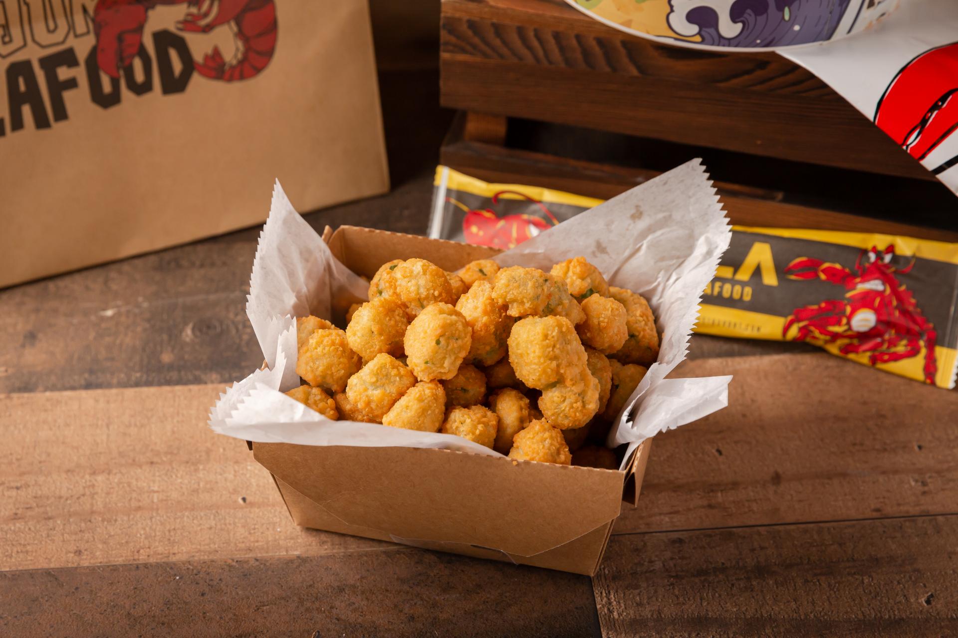 Crispy fried seafood bites in a paper tray at Aquabite Cajun Seafood, a Seafood Restaurant in Pasaden