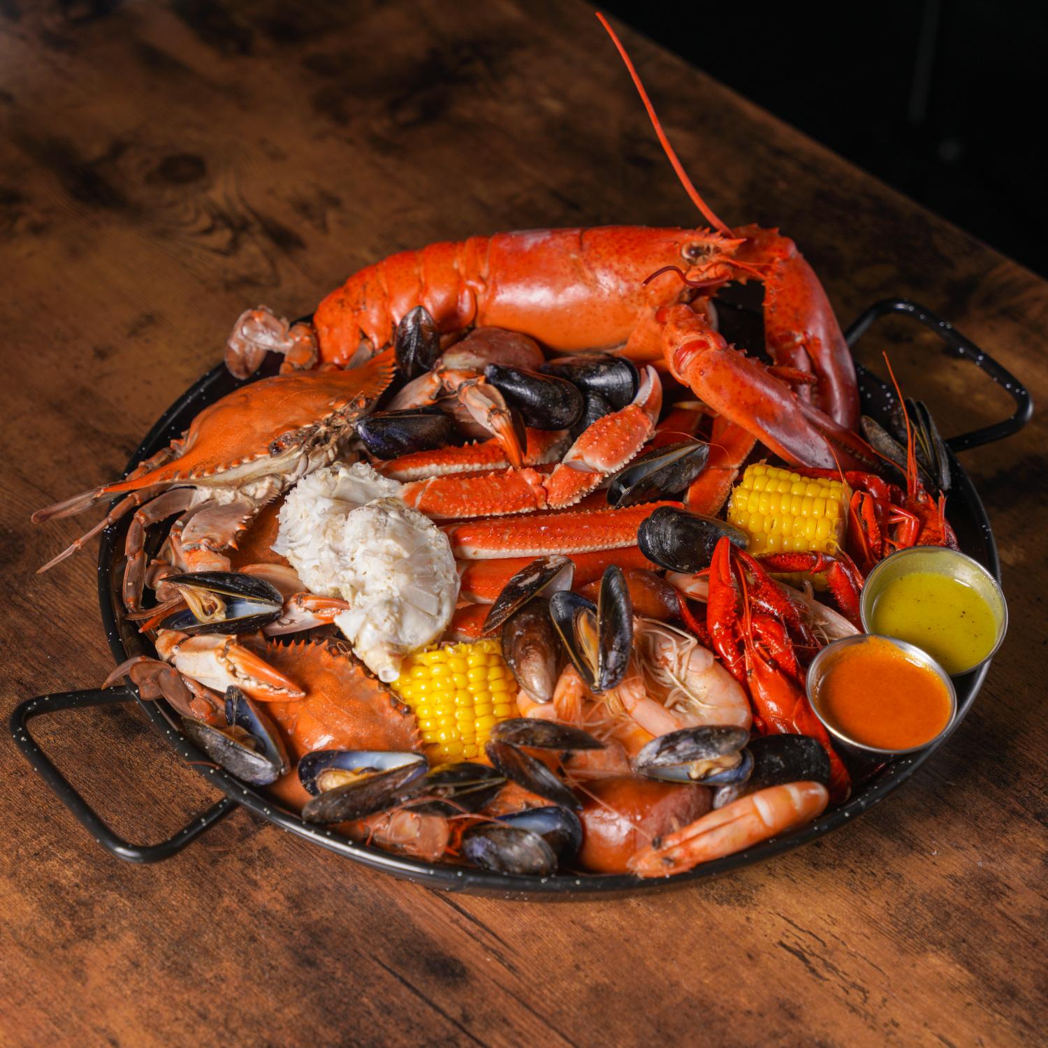Aquabite-Cajun-Seafood-Restaurant-Lobster-Crawfish-And-Mussels-Platter-Pasaden Platter with lobster, crawfish, mussels and dipping sauces at Aquabite Cajun Seafood, a Seafood Restaurant in Pasaden
