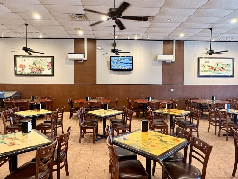 Bright dining area with ceiling fans & art at Asia Cafe, a Chinese Restaurant in Austin