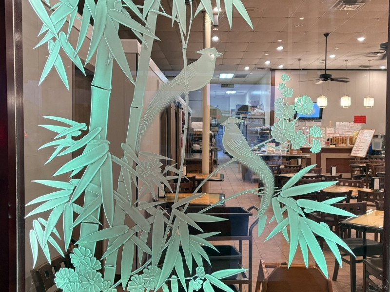 Entrance window with bamboo & bird decals at Asia Cafe, a Chinese Restaurant in Austin