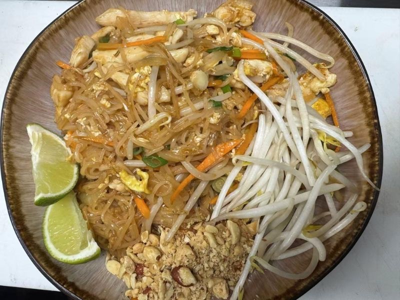 Saigon-Bistro-Vietnamese-Restaurant-Thai-Pad-Thai-Savannah Stir-fried rice noodles with chicken, vegetables, bean sprouts, peanuts, and lime wedges.