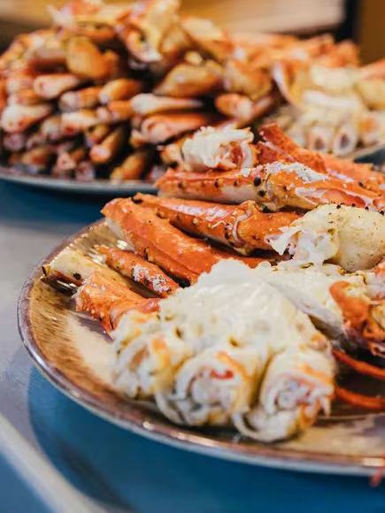 Plates piled high with cooked crab legs and crab meat, ready to be served.