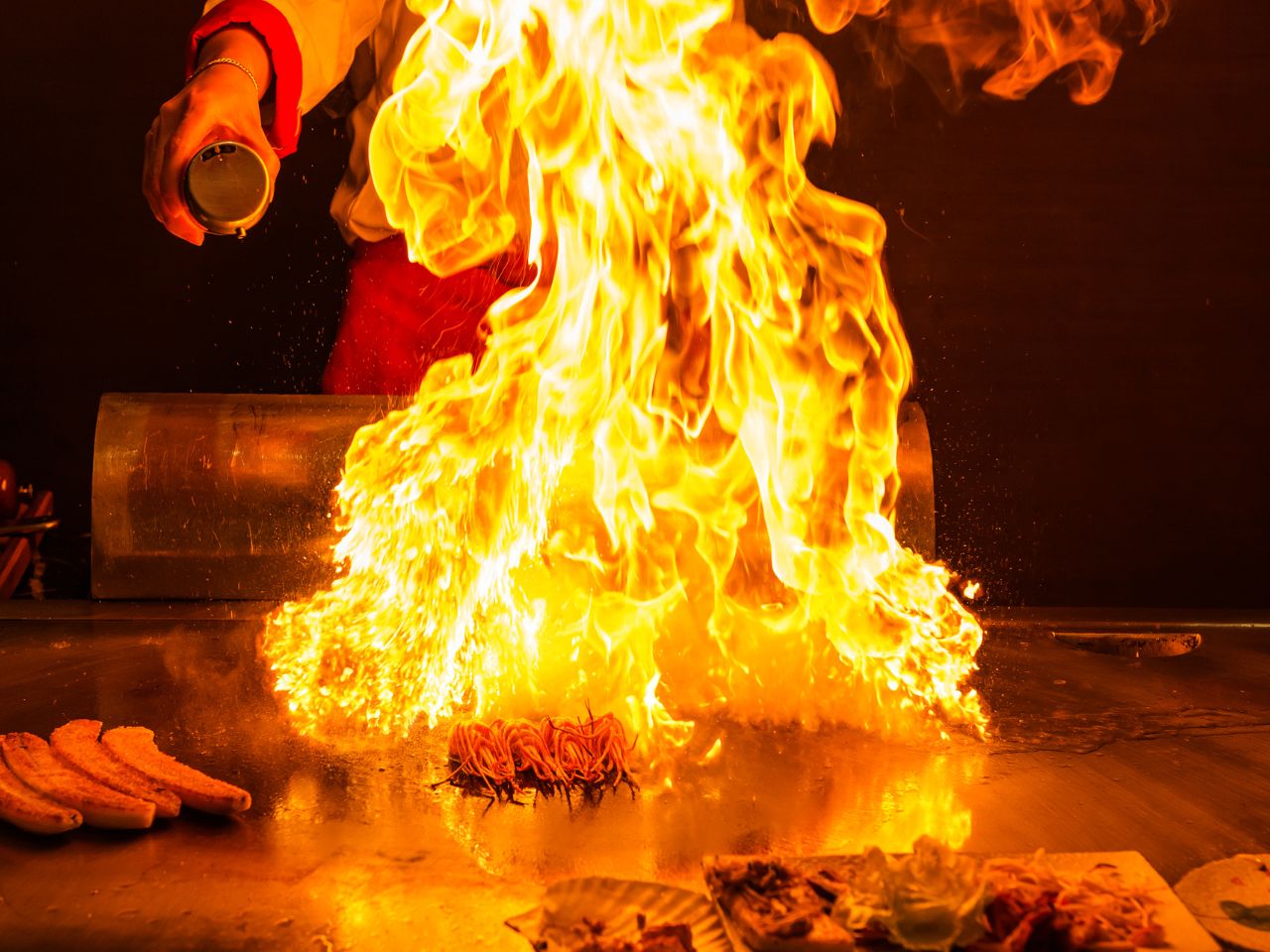 Teppanyaki cooking show with flames and grilling ingredients at AYCE Bar & Wok, an Asian Fusion Restauran in Wind Gap