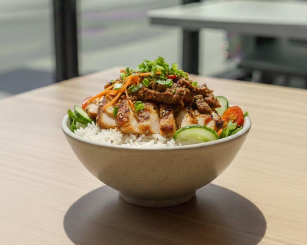 Grilled chicken over rice with spicy sauce and veggies at AZN Bowls. Bao. Juice Bar, a Health food Restaurant in Duluth