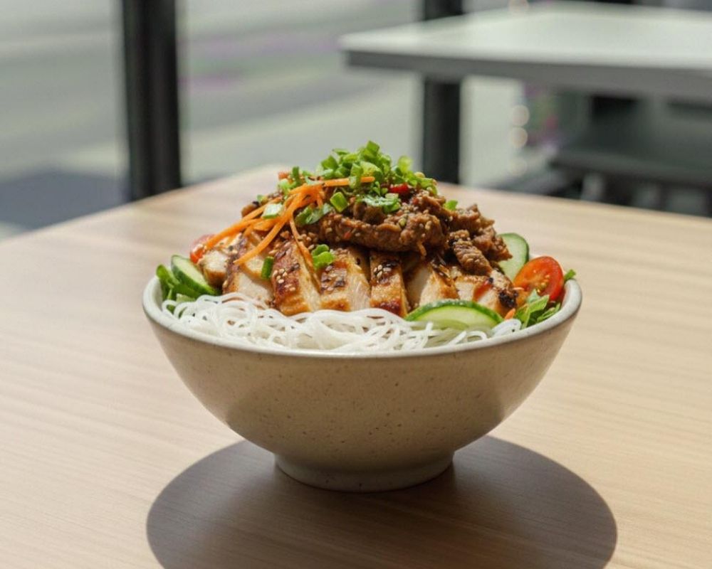 Grilled chicken over rice noodles with spicy sauce at AZN Bowls. Bao. Juice Bar, a Health food Restaurant in Duluth