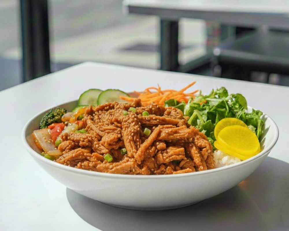 Sesame ginger chicken bowl with fresh veggies at AZN Bowls. Bao. Juice Bar, a Health food Restaurant in Duluth