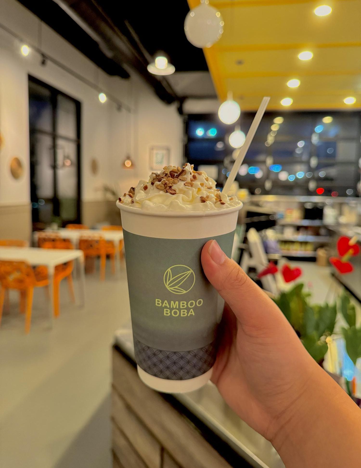 Nutty Cream Topped Milk Tea features a cup of milk tea with a swirl of whipped cream and crunchy nuts at Bamboo Boba, a Bubble Tea Shop in Beaverton