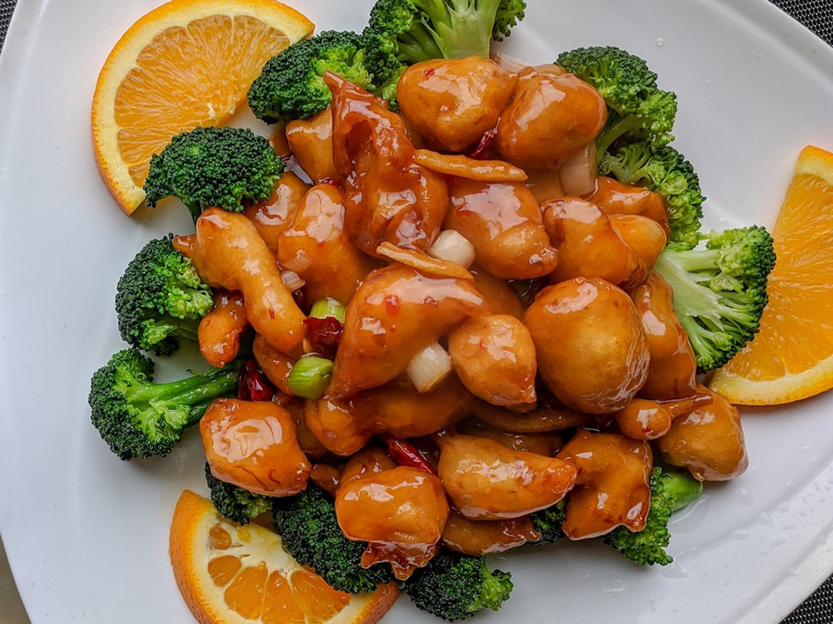 Tangy glazed orange chicken with broccoli and fresh orange slices on a white plate at Bamboo Express, a Chinese Restaurant in Bellingham