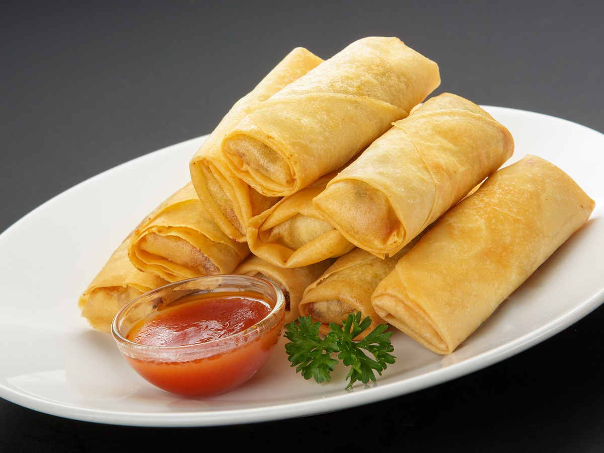 Crispy golden spring rolls with sweet chili dipping sauce on a white oval plate at Bamboo Express, a Chinese Restaurant in Bellingham