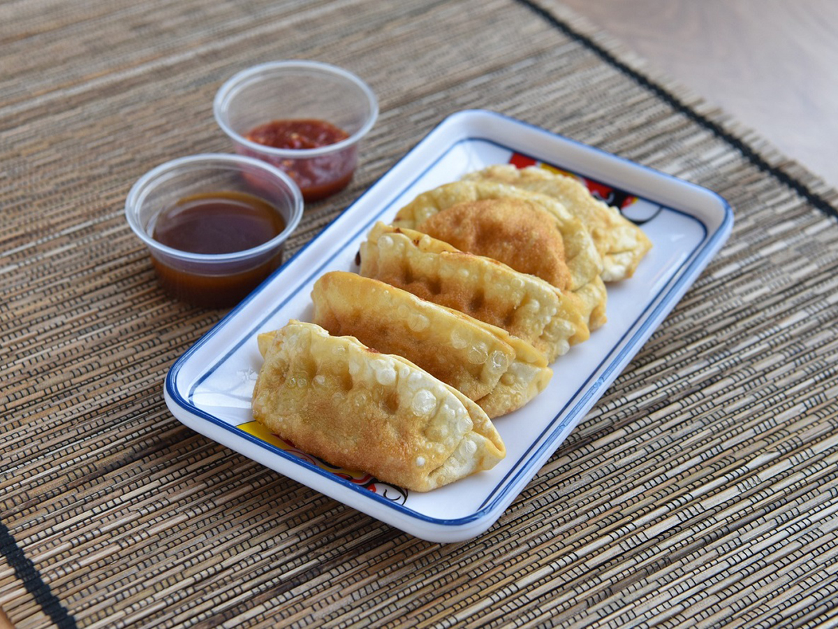 Pan-fried dumplings served with two side sauces on a rectangular ceramic plate at Bamboo Express, a Chinese Restaurant in Bellingham