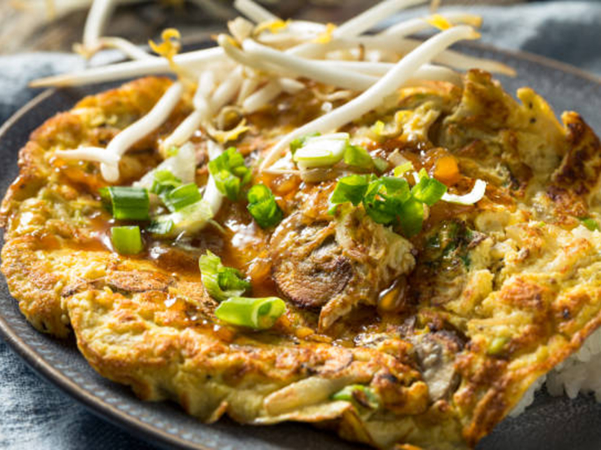 Golden egg foo young topped with bean sprouts, green onions and brown gravy at Kim's Chinese Food, a Chinese Restaurant in Hampton