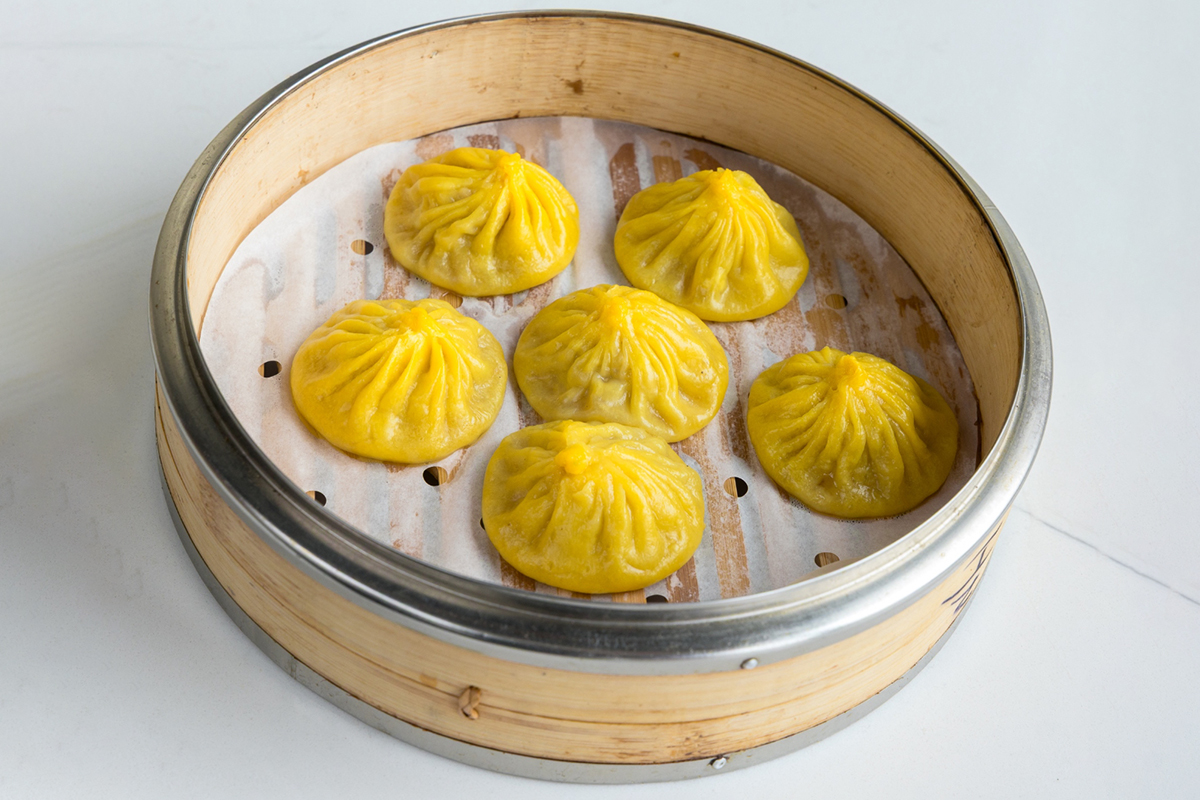 Steamed chicken soup dumplings (xiaolongbao) in bamboo steamer at Baobao Asian Eatery, an Asian Restaurant in Ann Arbor