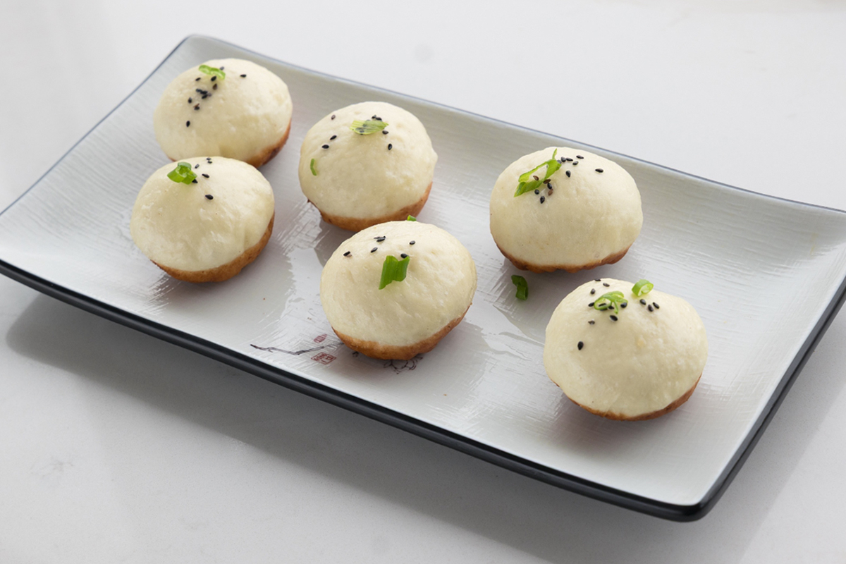 Pan-fried chicken buns with sesame seeds on plate at Baobao Asian Eatery, an Asian Restaurant in Ann Arbor