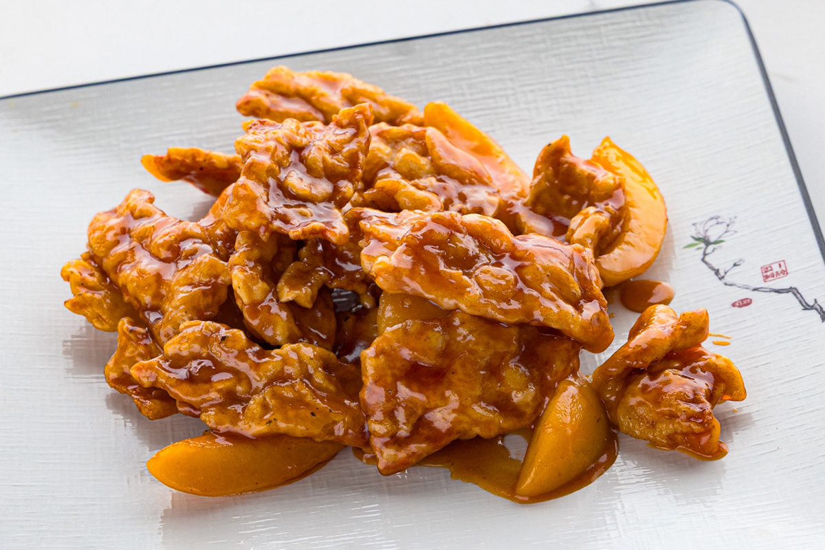 Sweet and sour pork with peach slices on plate at Baobao Asian Eatery, an Asian Restaurant in Ann Arbor