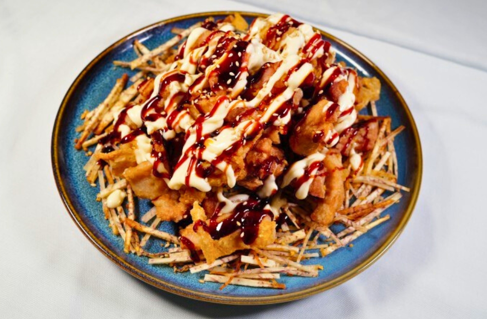 Crispy chicken drizzled with sauces, served on fried taro strips at Bao Kee Restaurant, a Chinese Restaurant in Hacienda Heights